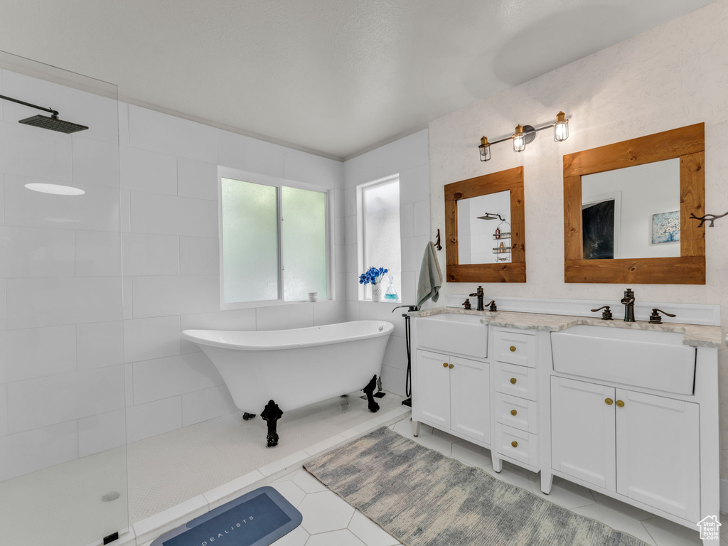 Bathroom with double vanity, a soaking tub, tile patterned floors, and a walk in shower
