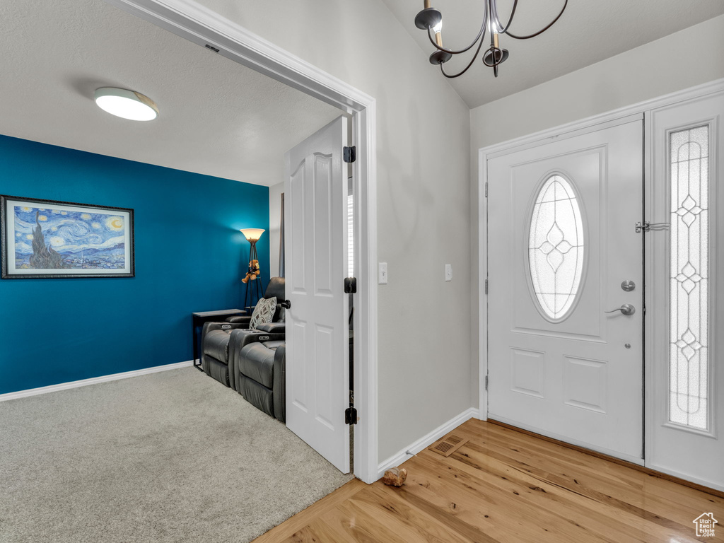 Foyer entrance featuring a chandelier and light wood finished floors