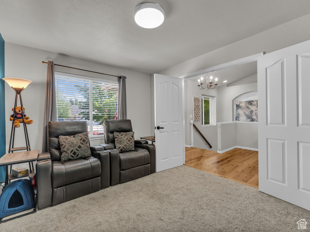 Living area with carpet flooring and a chandelier