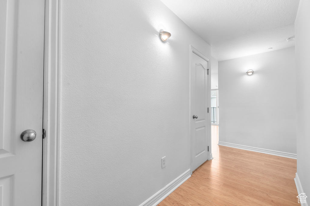 Corridor featuring baseboards and light wood-style flooring