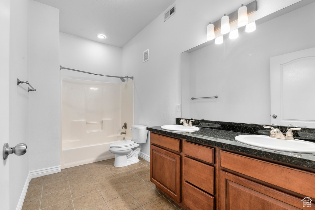 Bathroom with double vanity, tile patterned floors, and  shower combination