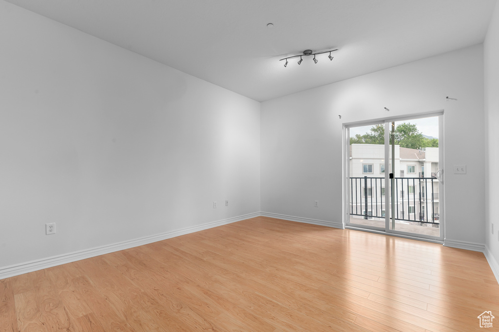 Unfurnished room featuring light wood-style floors and rail lighting