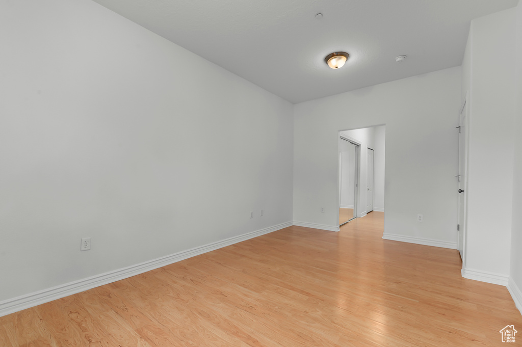 Empty room featuring light wood-style floors and a smoke detector