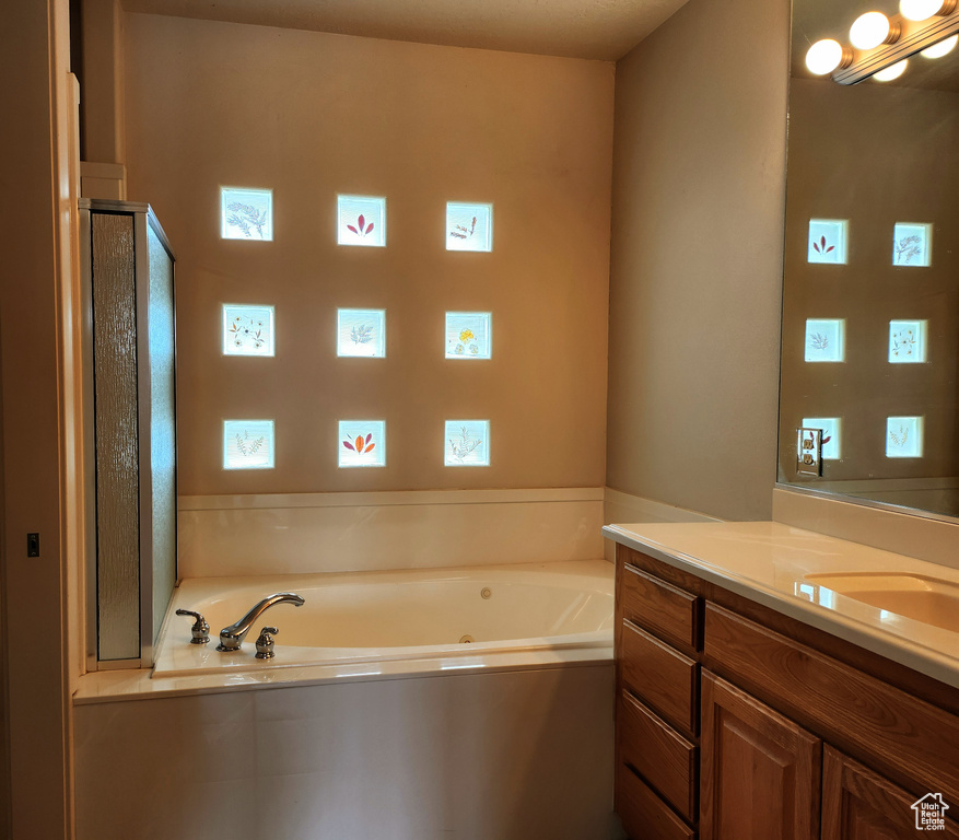 Bathroom with vanity and a jetted tub