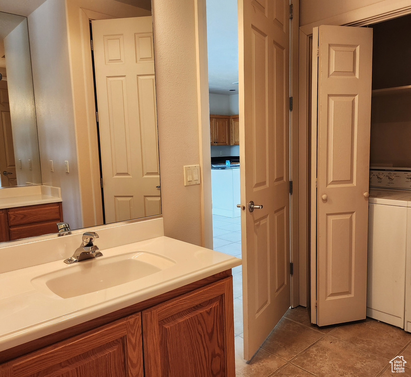 Bathroom featuring washer / clothes dryer, vanity, and tile patterned floors