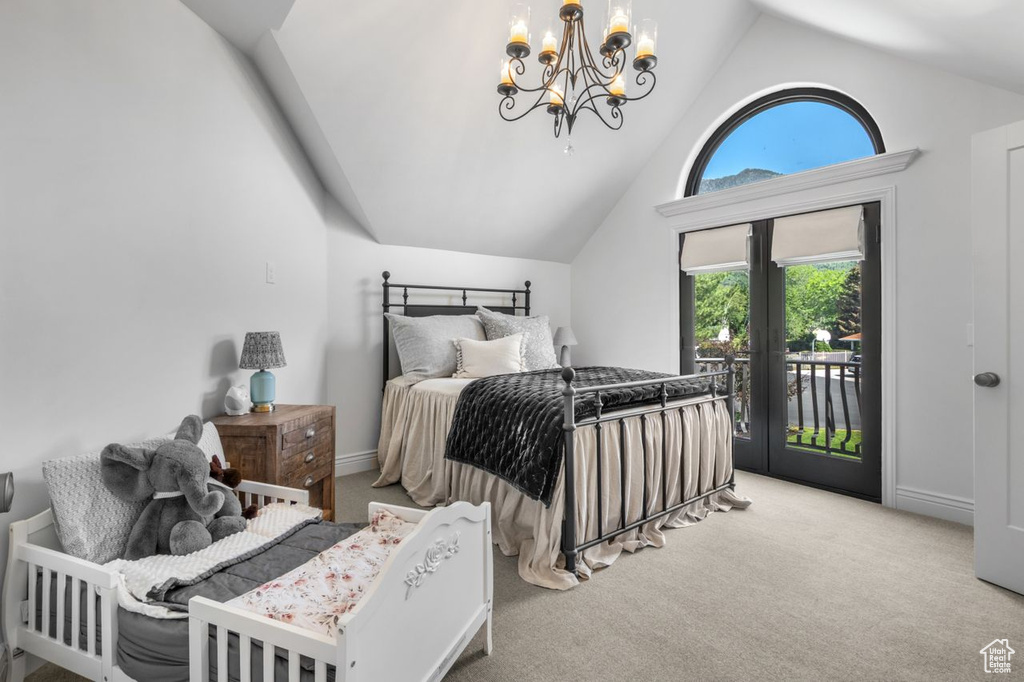Bedroom with vaulted ceiling, access to outside, carpet flooring, and a chandelier