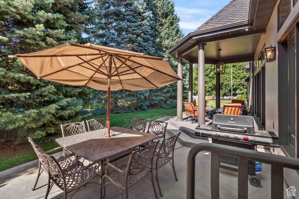 View of patio with outdoor dining area and grilling area