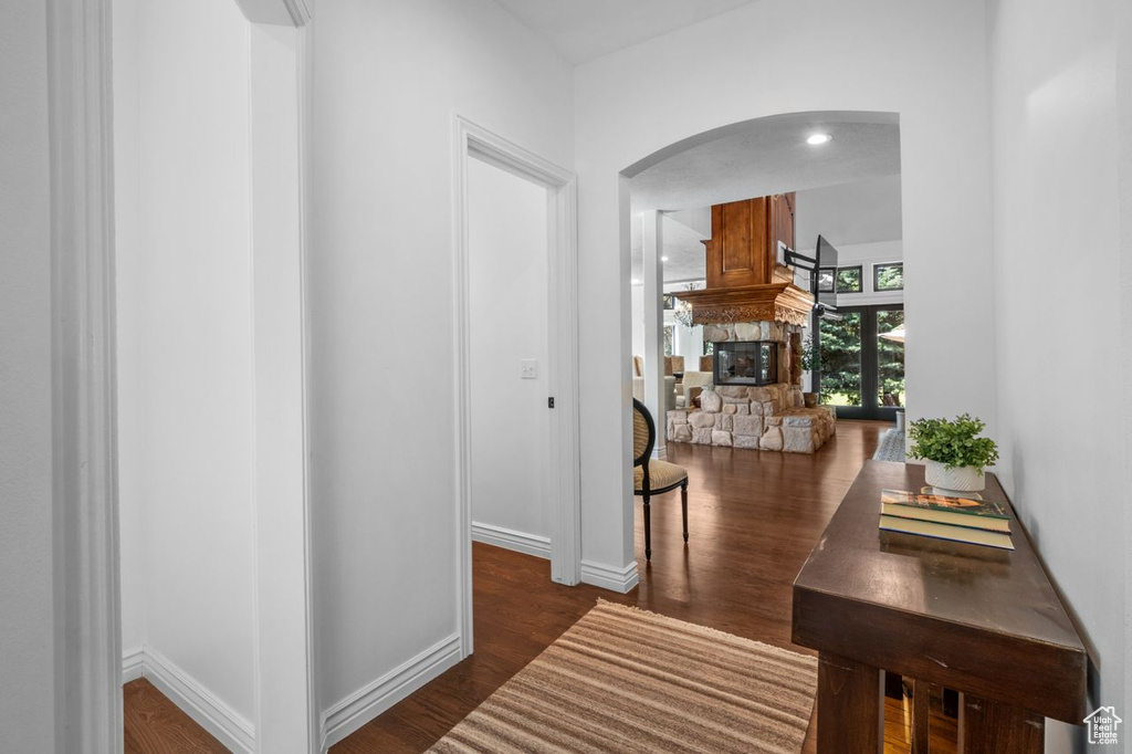 Corridor featuring arched walkways and dark wood finished floors