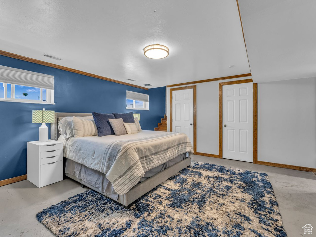 Bedroom featuring finished concrete floors and ornamental molding