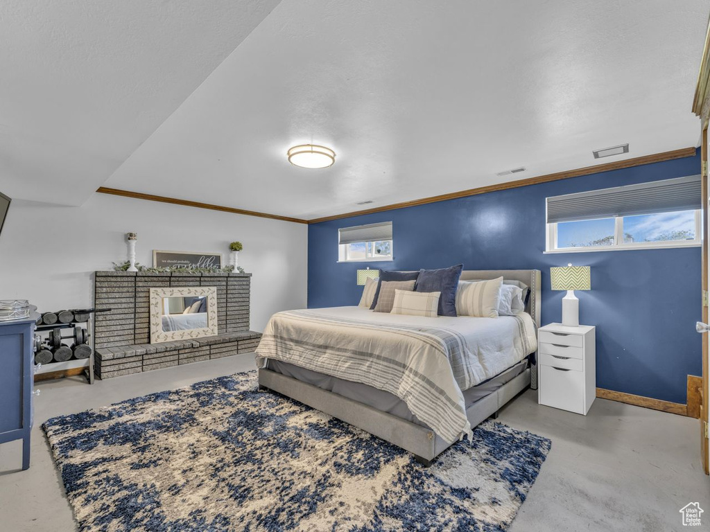 Bedroom with finished concrete flooring and ornamental molding