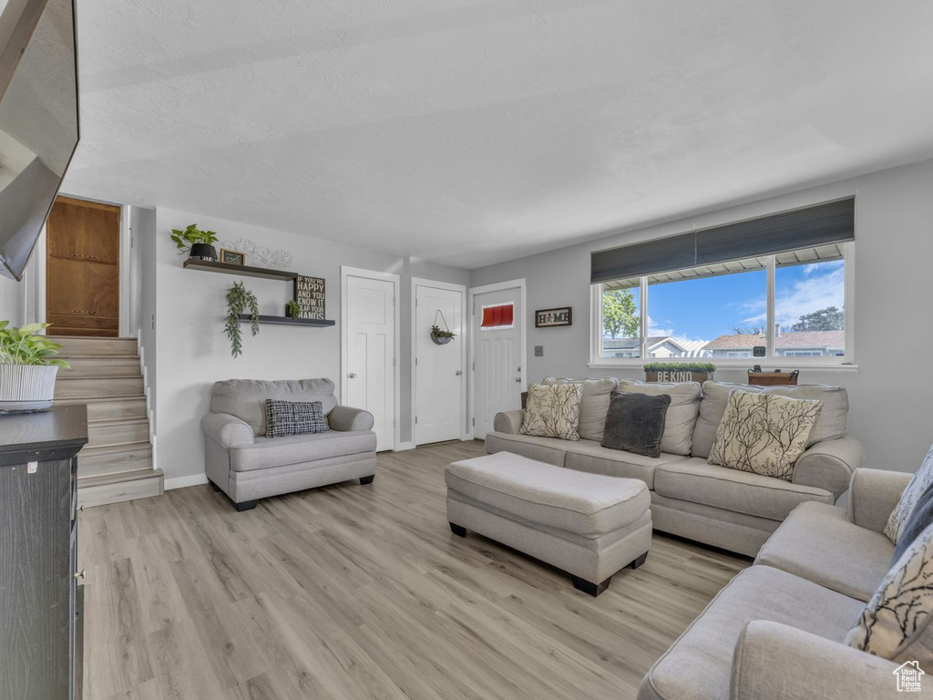 Living area featuring light wood-style flooring and stairs