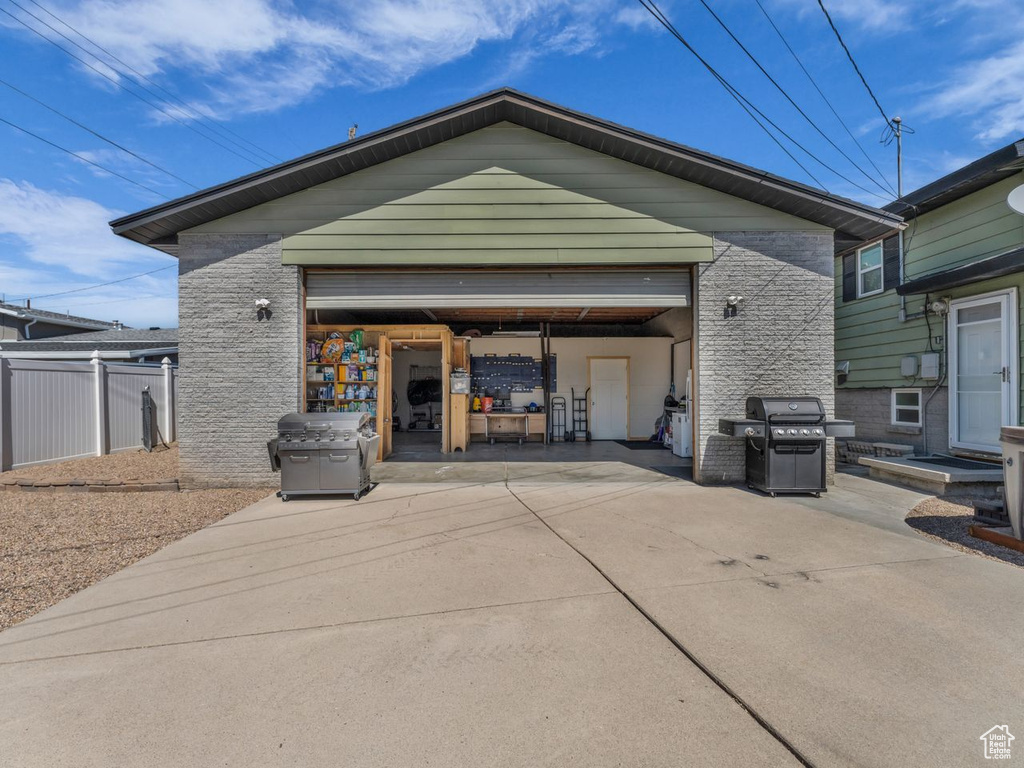Back of house featuring a garage and stone siding