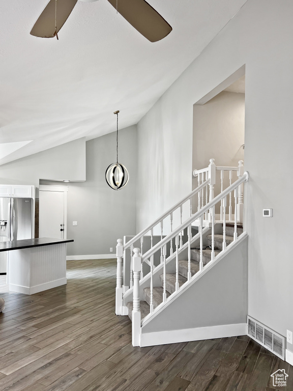 Stairway featuring lofted ceiling and wood finished floors