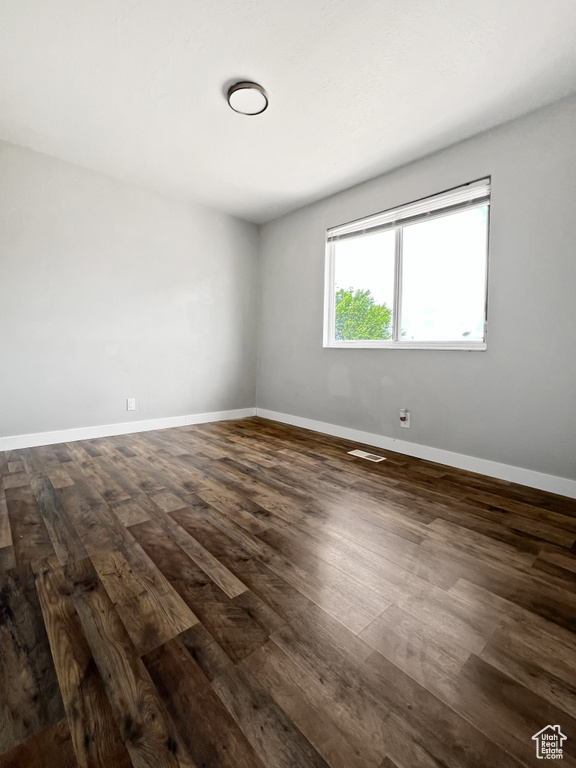 Unfurnished room with dark wood-style floors and baseboards