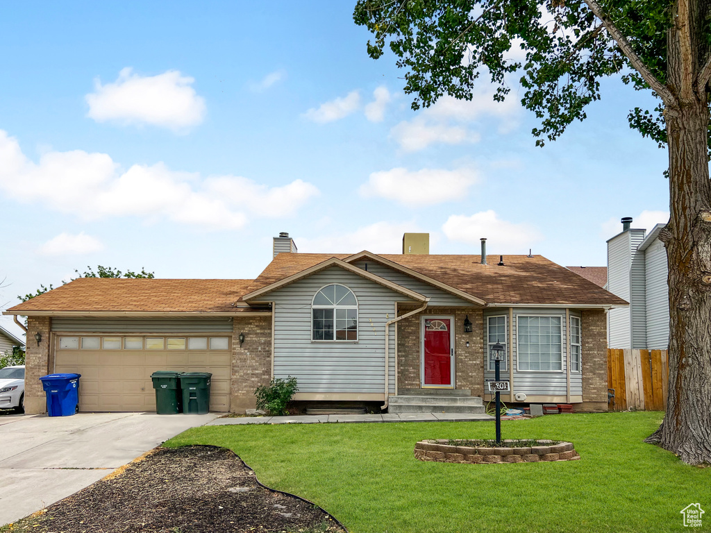 Ranch-style house with brick siding, concrete driveway, an attached garage, and entry steps