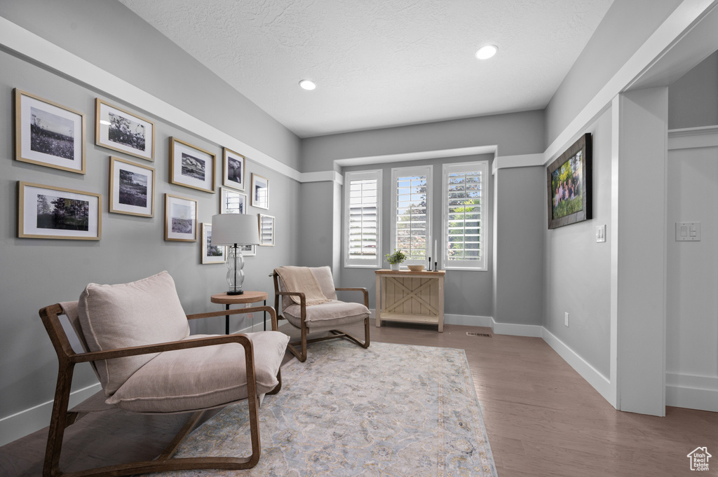Living area with wood finished floors and recessed lighting