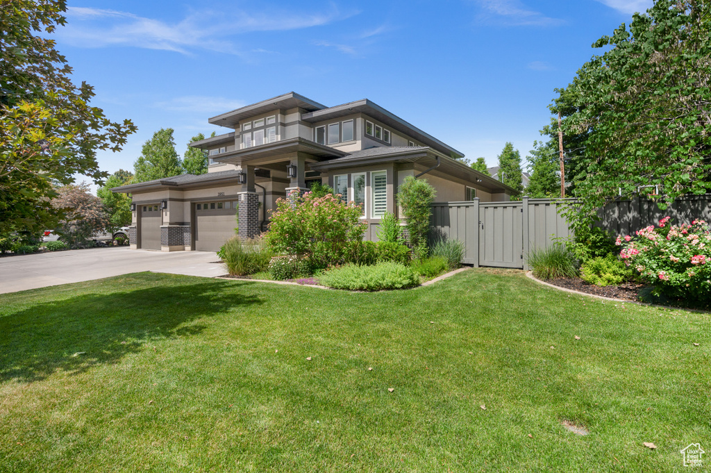 Prairie-style home with driveway, a gate, and a garage