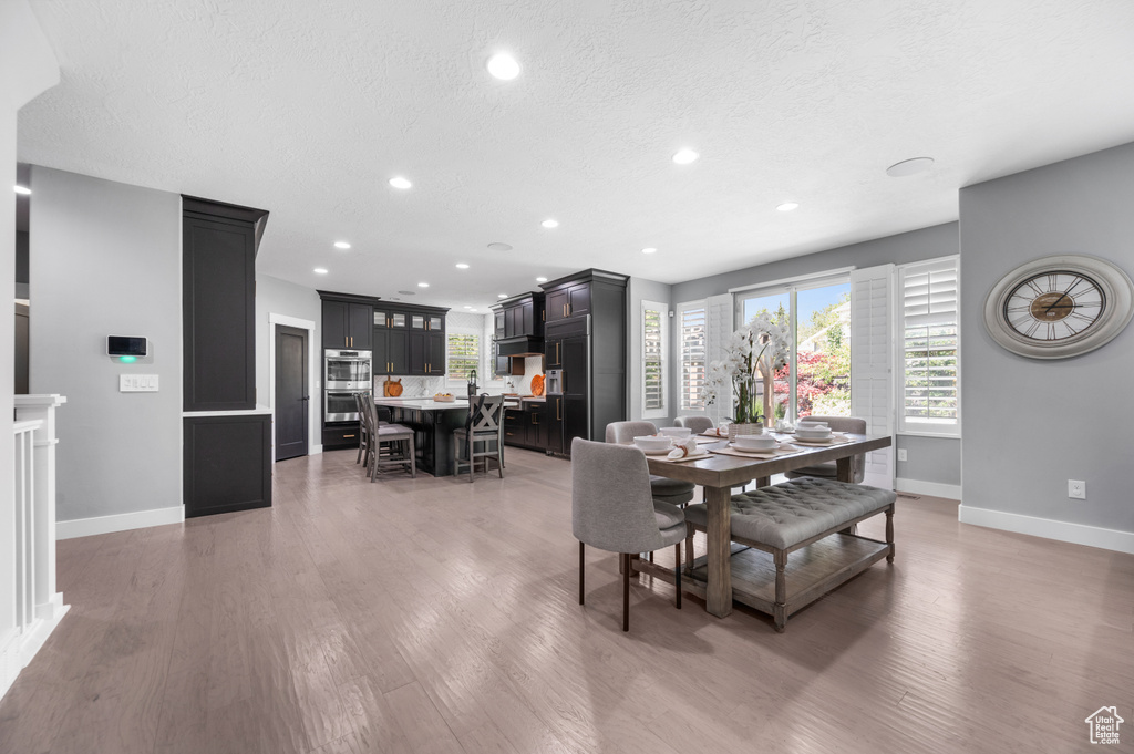 Dining room featuring recessed lighting, light wood-style floors, and a textured ceiling