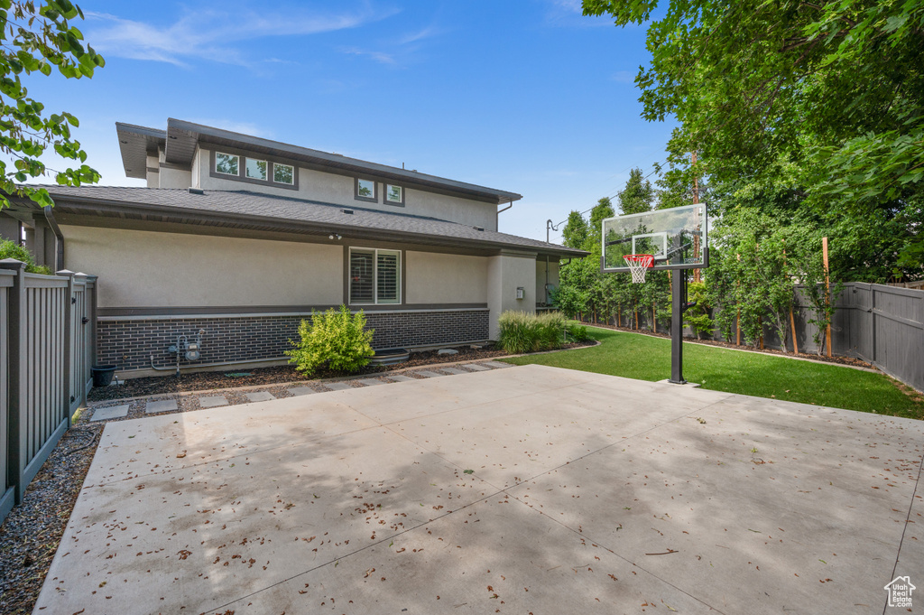 Rear view of property featuring stucco siding, brick siding, a fenced backyard, and a patio area