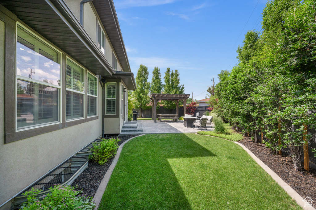 Fenced backyard featuring a pergola and a patio area
