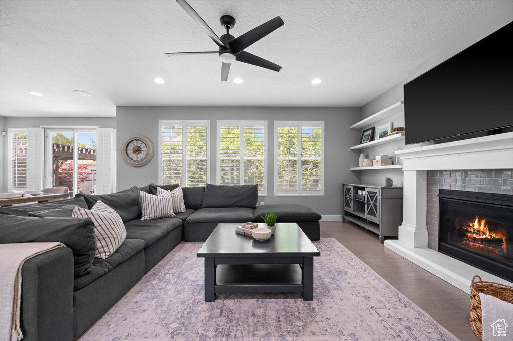 Living room featuring plenty of natural light, recessed lighting, wood finished floors, a textured ceiling, and ceiling fan