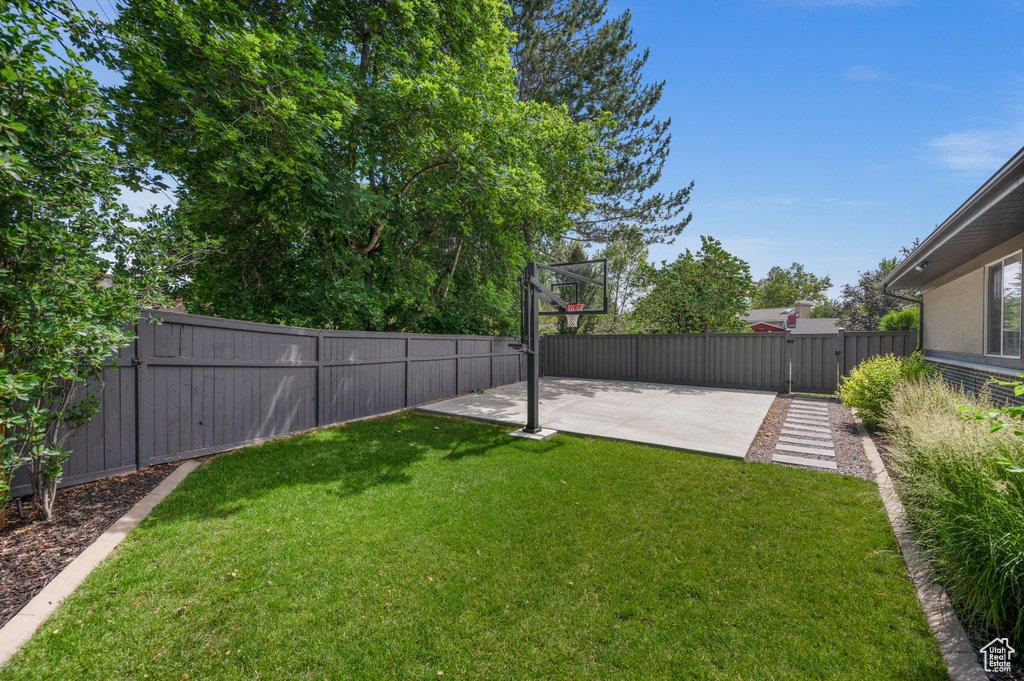 Fenced backyard featuring a gate and a patio area