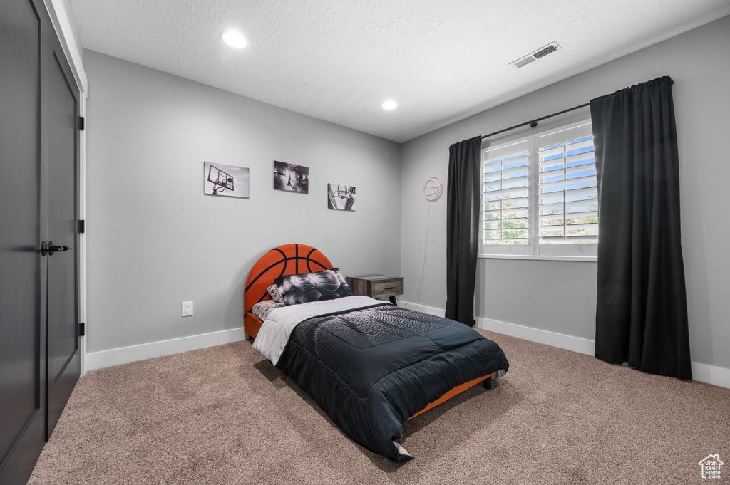 Bedroom featuring carpet floors, recessed lighting, and a textured ceiling