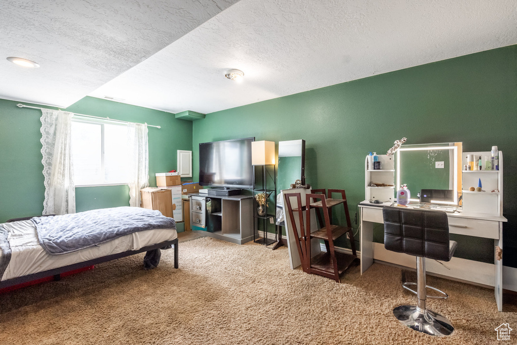 Bedroom featuring carpet floors, a textured ceiling, and an office area
