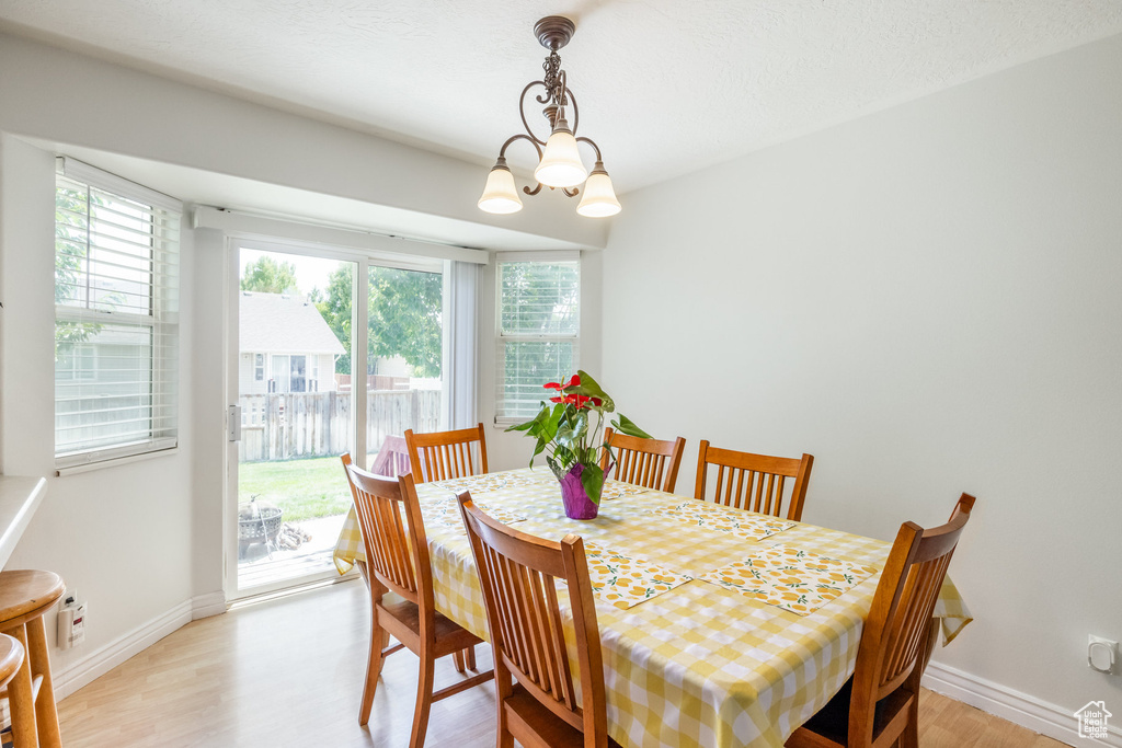 Dining area featuring light wood-type flooring and a chandelier