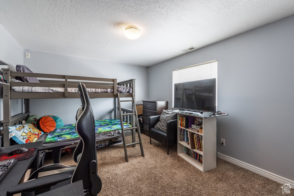 Bedroom with carpet and a textured ceiling