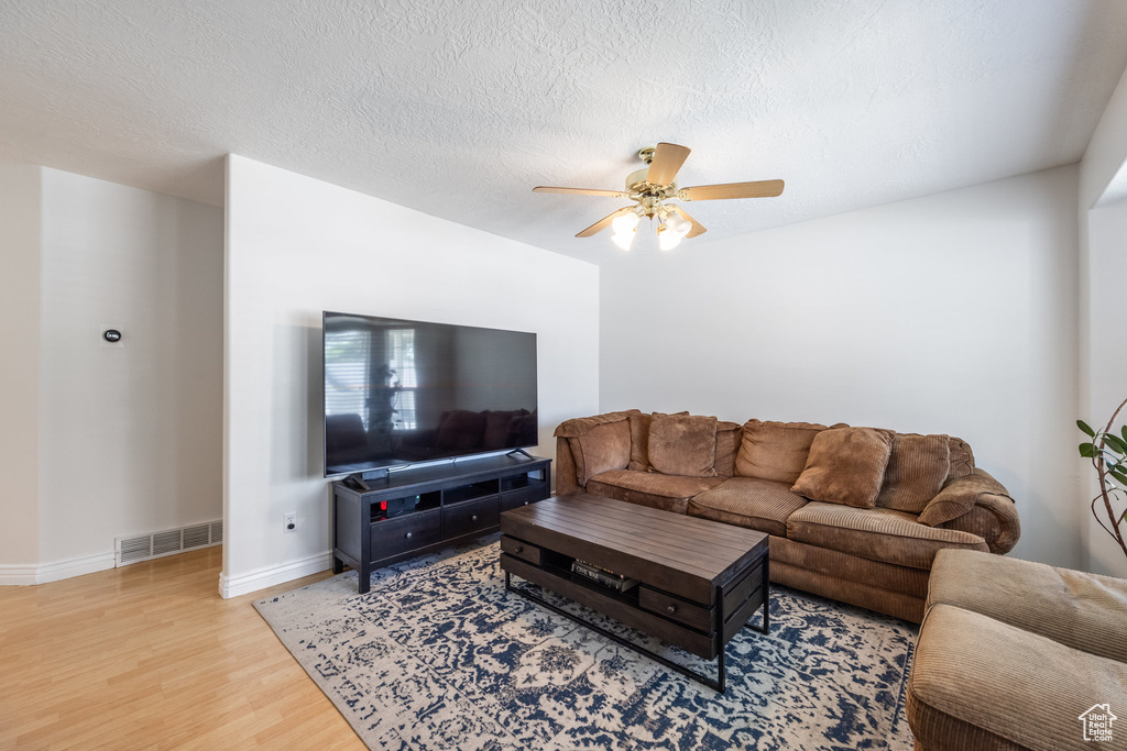 Living room with light wood-style floors and ceiling fan