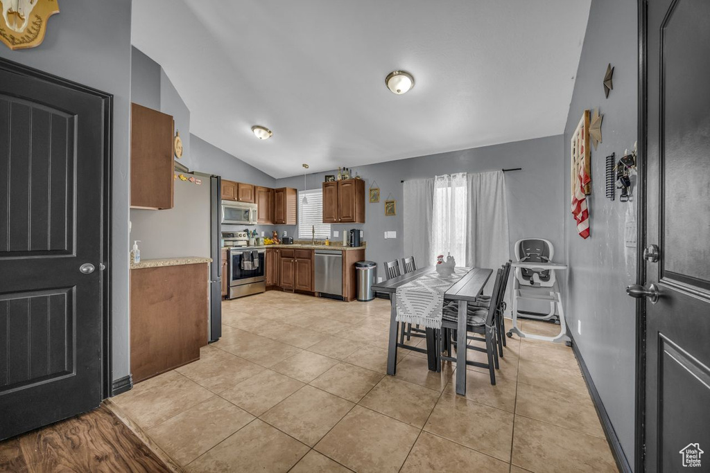 Dining area with lofted ceiling and light tile patterned floors