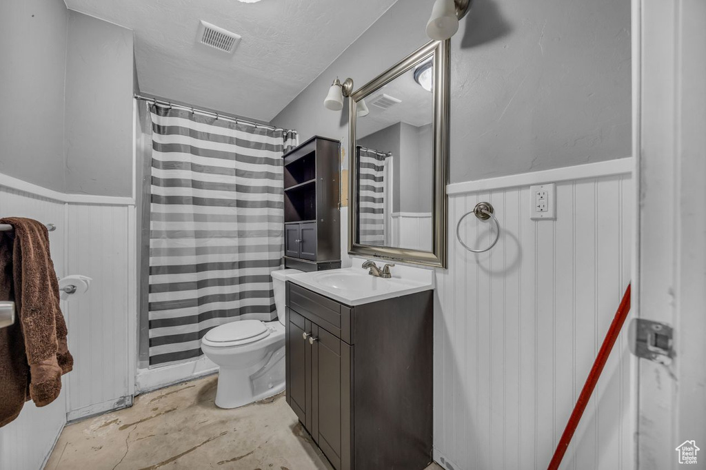 Bathroom featuring wainscoting, vanity, and a shower with shower curtain