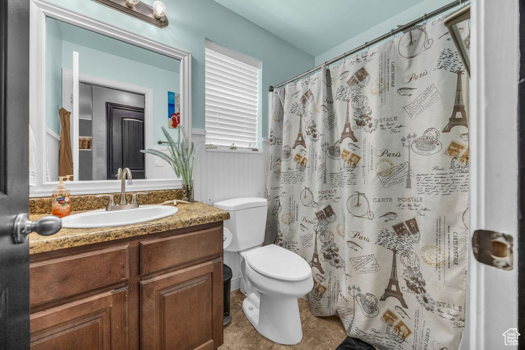 Bathroom with vanity, wainscoting, and a shower with shower curtain