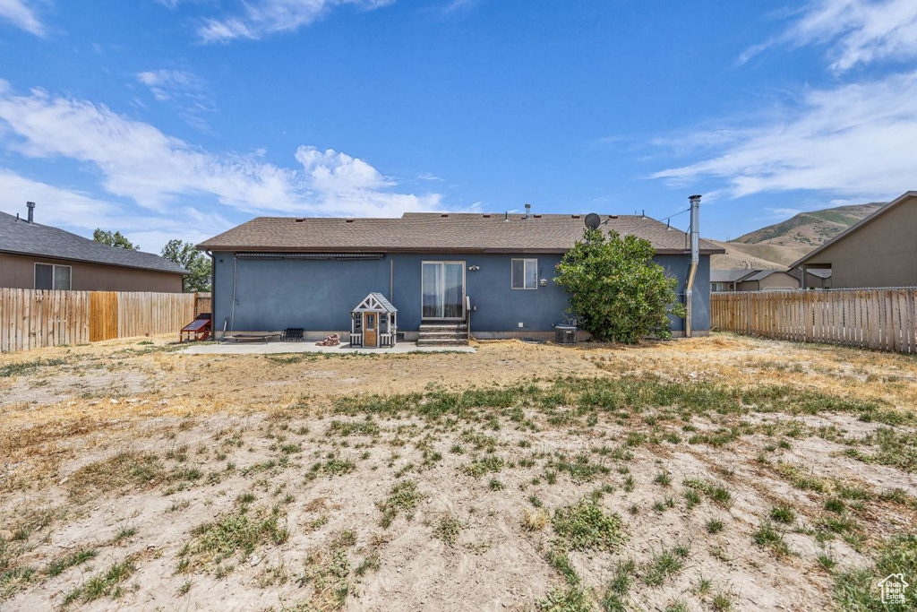 Back of property featuring a fenced backyard, a patio area, stucco siding, and entry steps