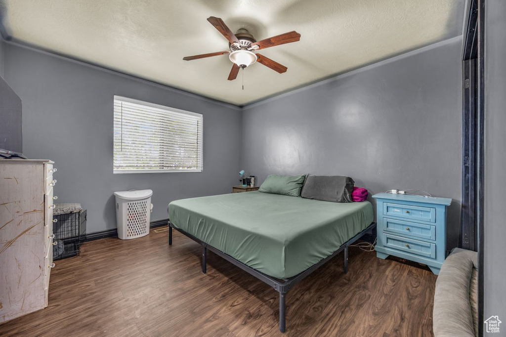 Bedroom featuring wood finished floors, a ceiling fan, and ornamental molding