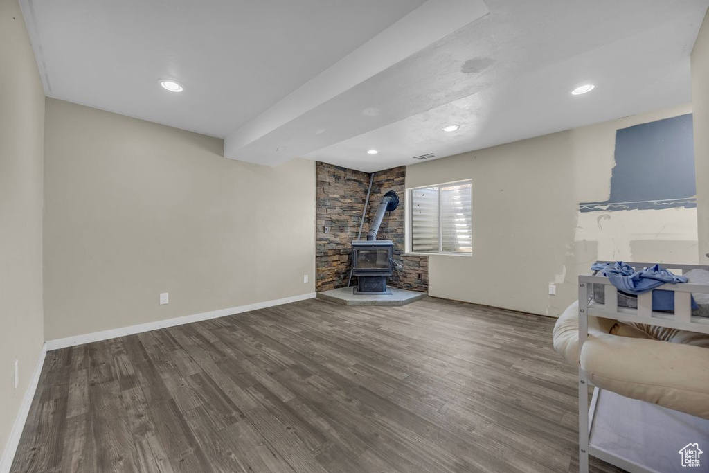 Living area featuring a wood stove, wood finished floors, and recessed lighting