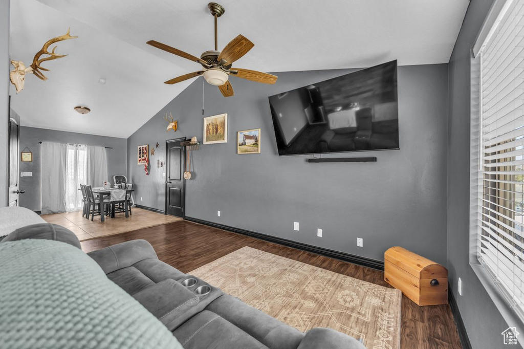 Living room with ceiling fan, lofted ceiling, and wood finished floors