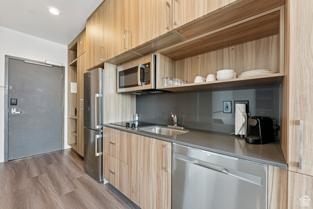 Kitchen featuring stainless steel appliances, open shelves, modern cabinets, and light brown cabinets