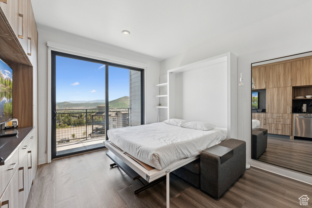 Bedroom featuring access to outside, dark wood-type flooring, recessed lighting, and a mountain view