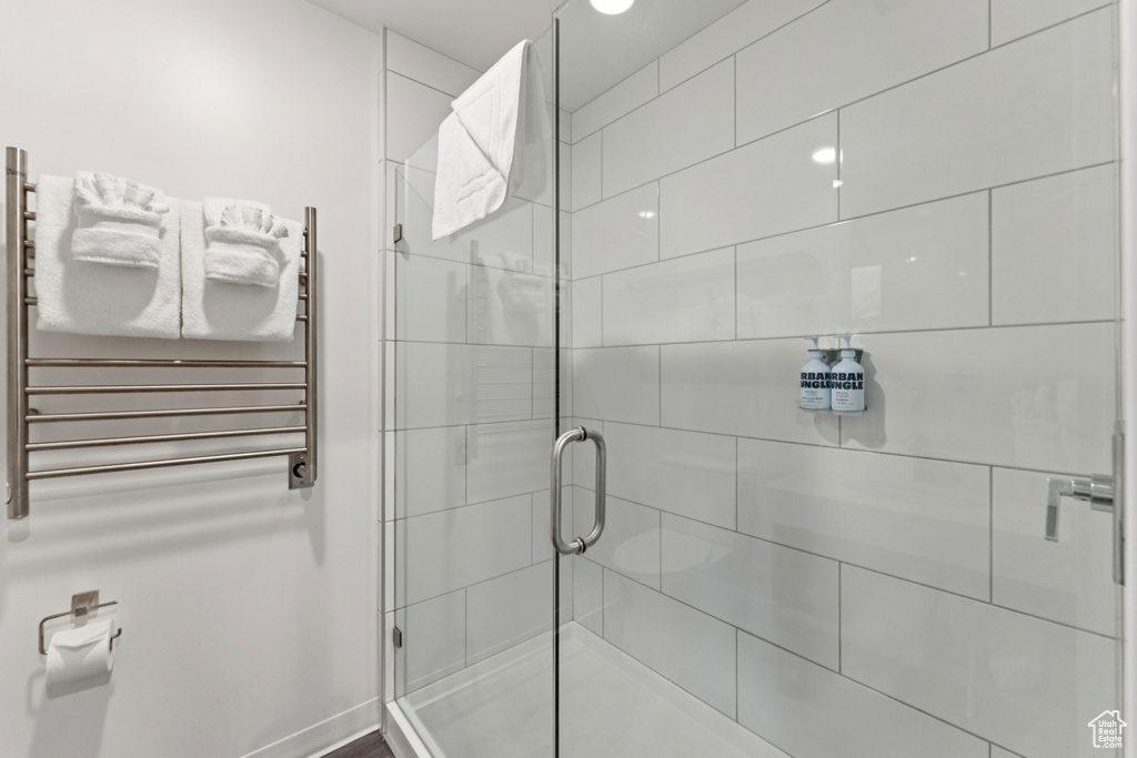 Full bath featuring radiator heating unit, a shower stall, and a towel warmer