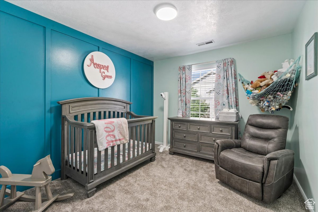 Bedroom with carpet and a crib