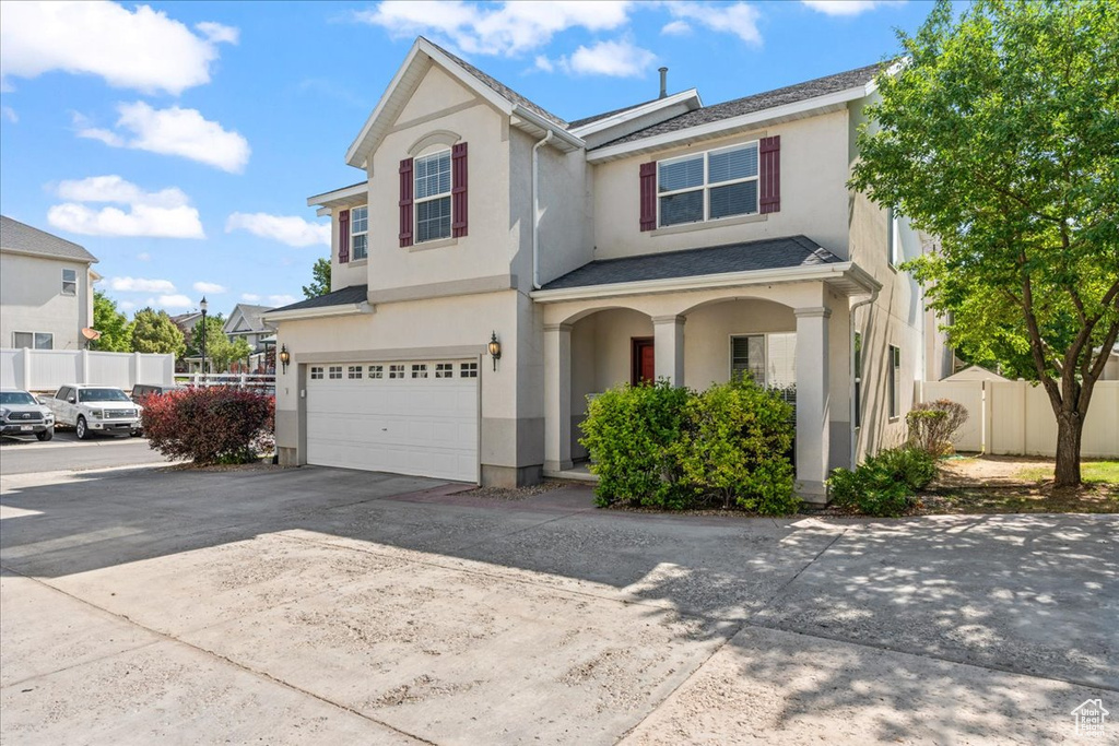View of front of property featuring a garage, stucco siding, and concrete driveway