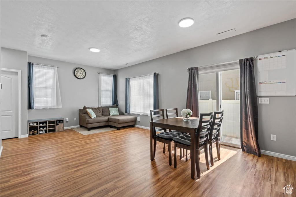 Dining space featuring wood finished floors and a textured ceiling