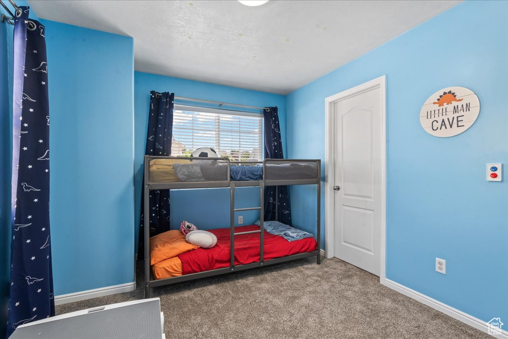 Bedroom featuring carpet and baseboards