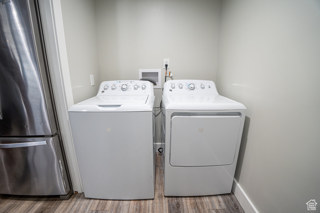 Laundry area with separate washer and dryer and wood finished floors