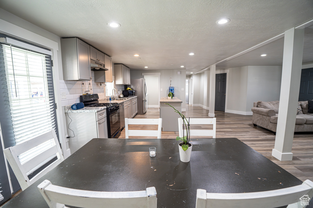 Dining space featuring light wood-style flooring, recessed lighting, and a textured ceiling