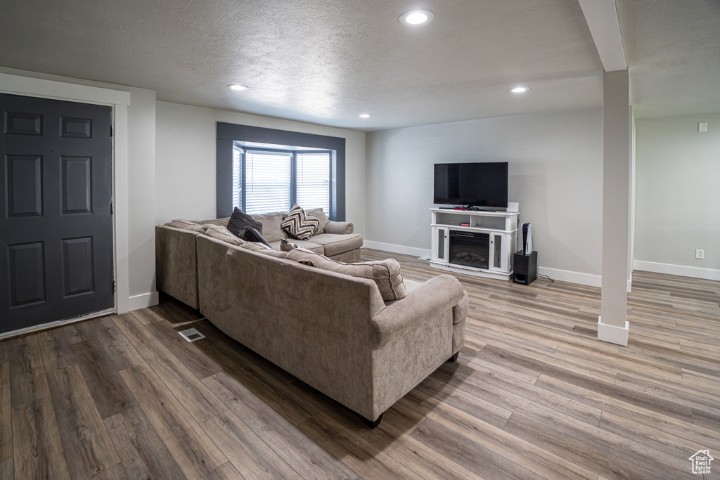 Living room featuring recessed lighting, wood finished floors, and a textured ceiling