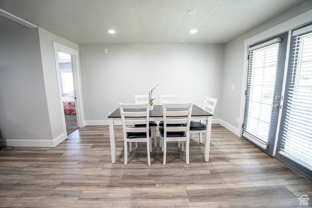 Dining area featuring healthy amount of natural light, recessed lighting, wood finished floors, and a textured ceiling