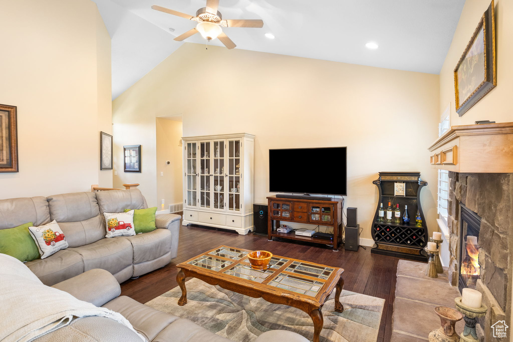 Living room with ceiling fan, hardwood / wood-style floors, high vaulted ceiling, a fireplace, and recessed lighting